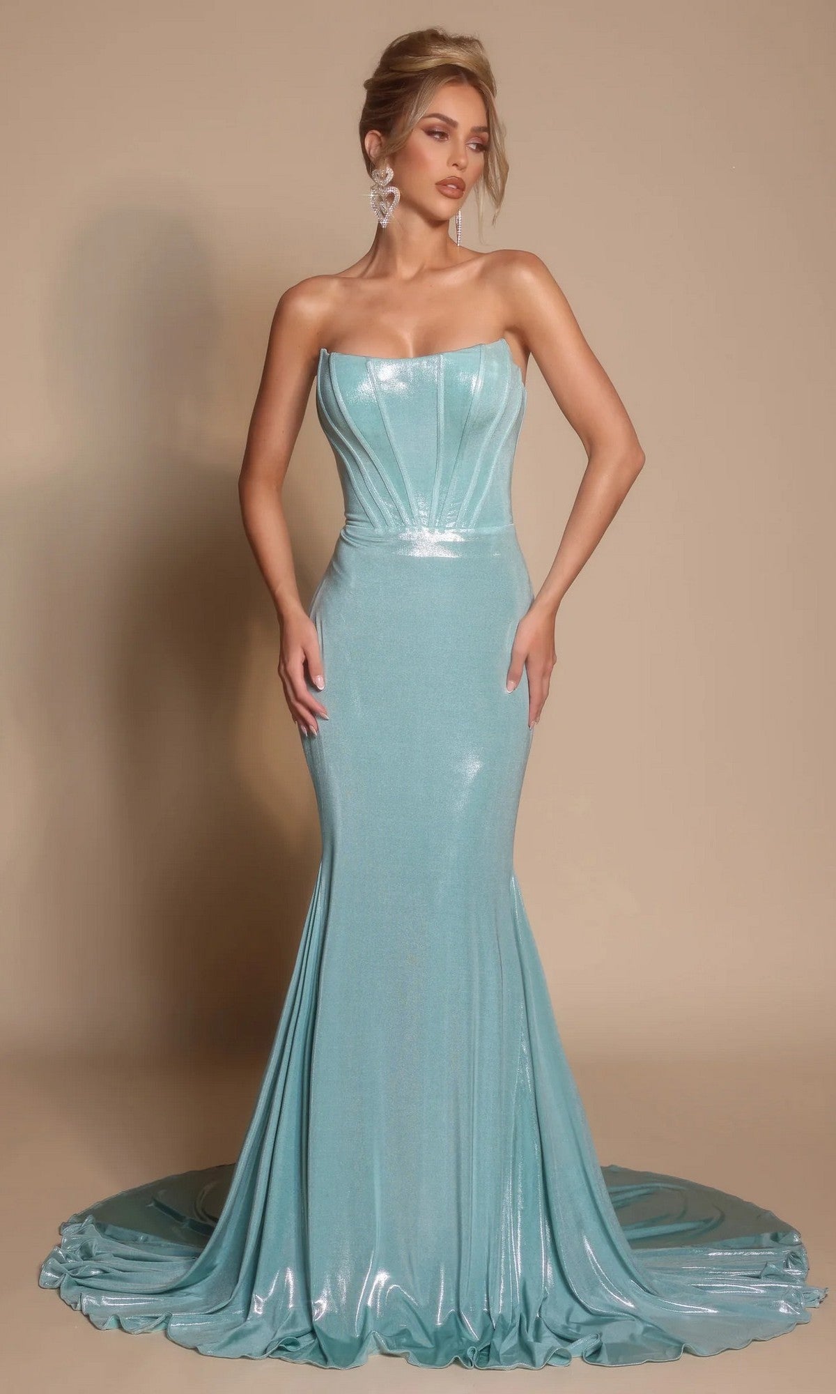 A woman wearing the Portia and Scarlett XO097 long formal dress in mint, featuring a strapless neckline, fitted mermaid silhouette, and floor-length train, stands against a plain beige background.